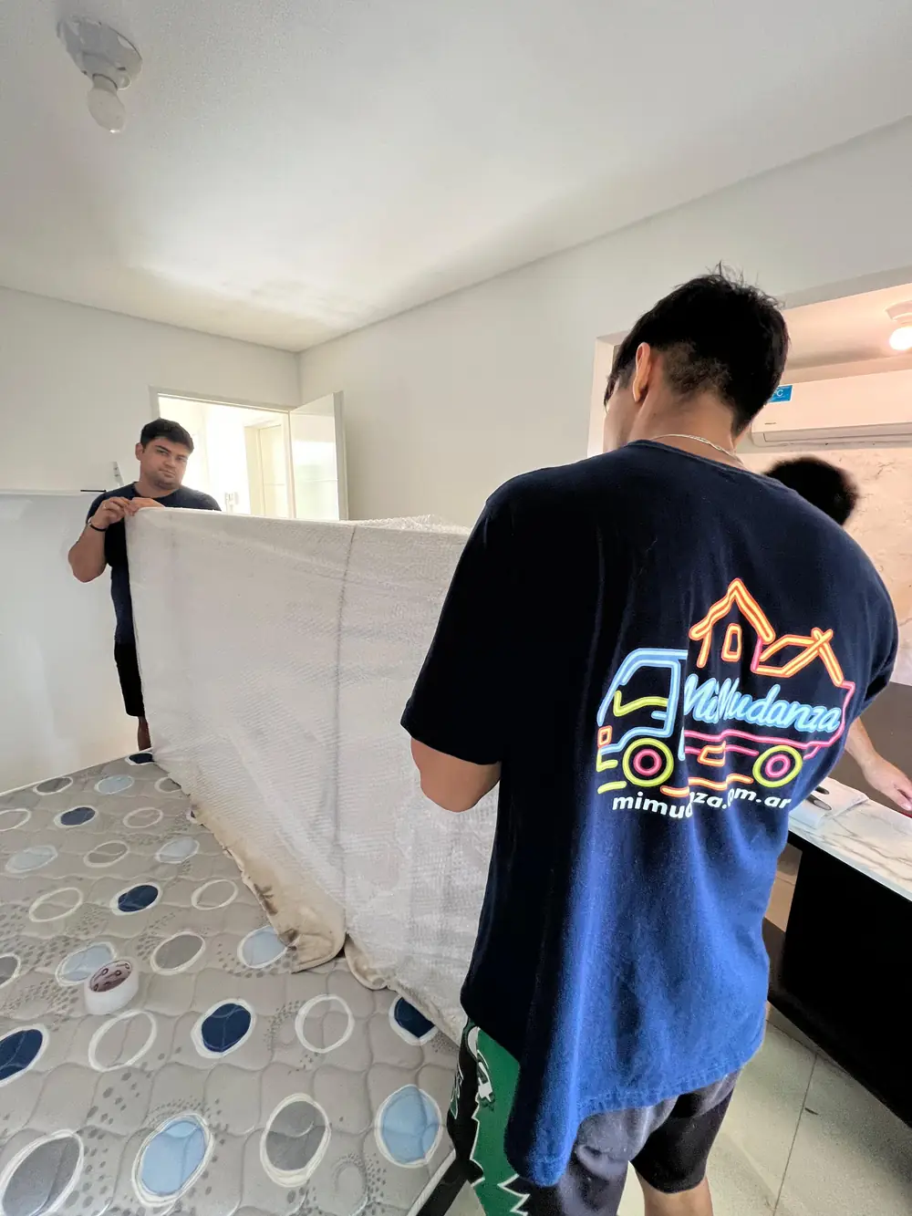 Personal de Mudandote embalando muebles dentro de una vivienda